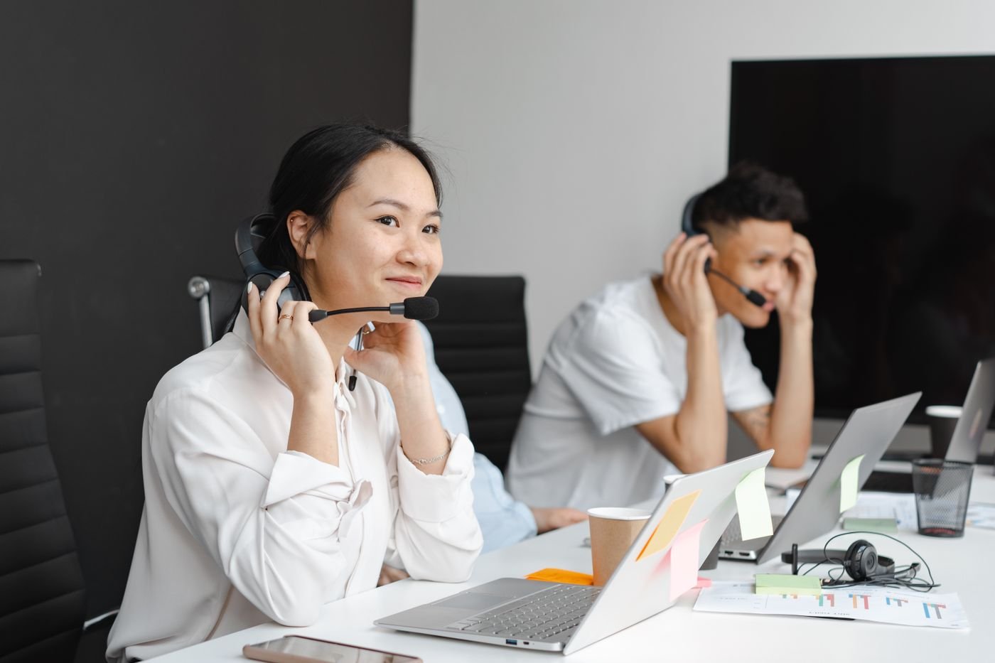 Two friendly customer support agents wearing headsets, ready to assist
